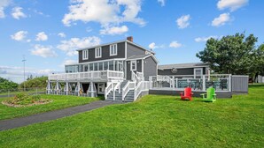 A large, two-story building with a covered porch and a fenced outdoor area.