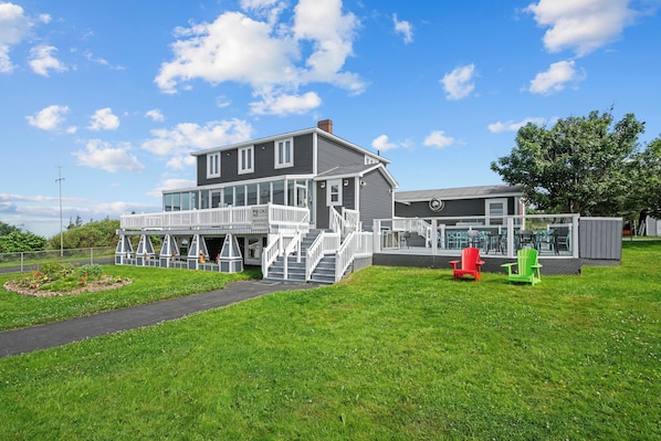 A large, two-story building with a covered porch and a fenced outdoor area.