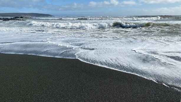 A beach with waves crashing onto the shore.