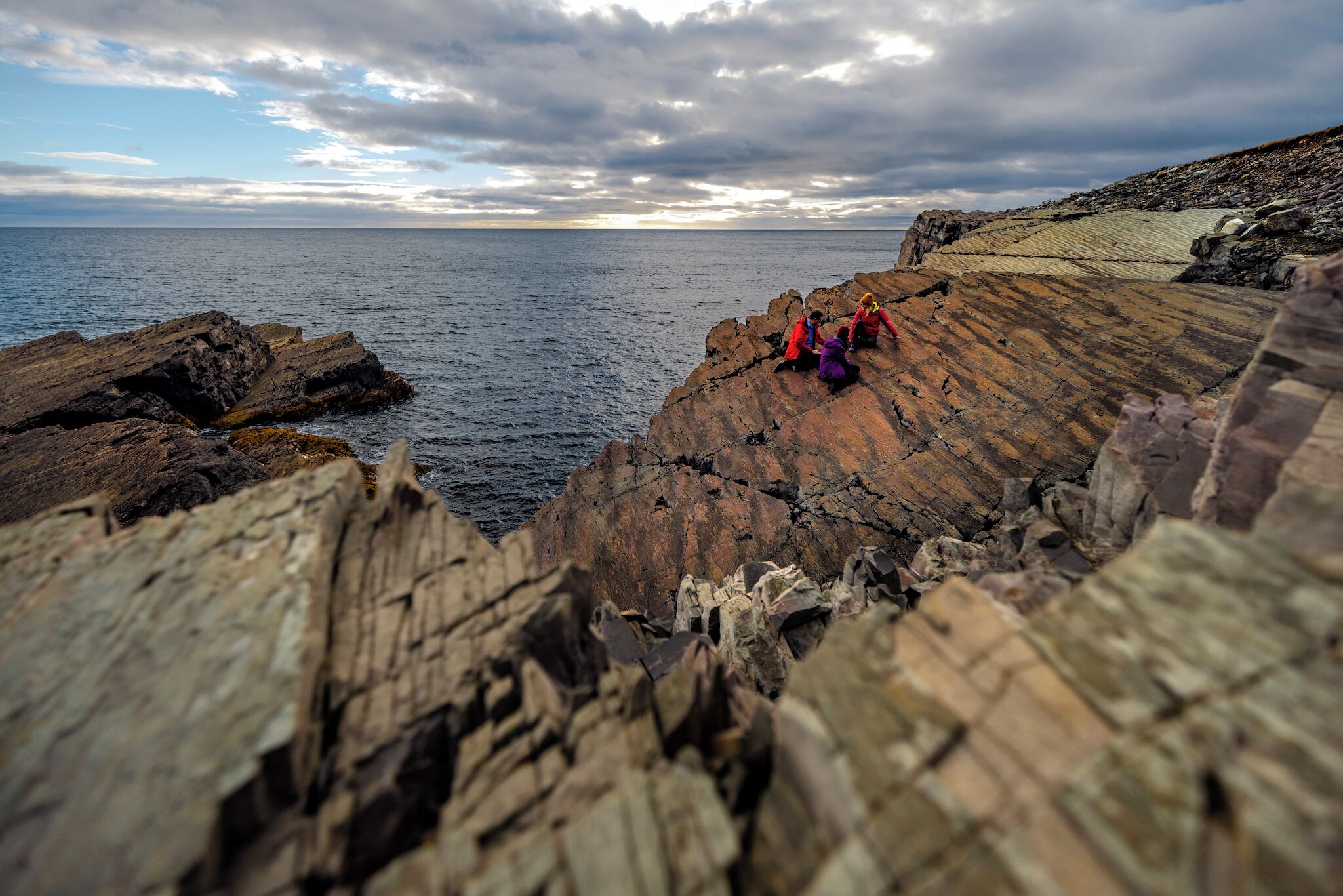 A rocky coastline with a view of the sea and sky.