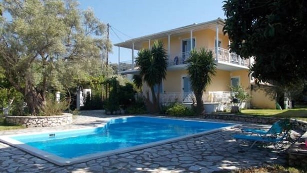 A two-story building with a swimming pool and a stone patio. - Iris Villa (Lefkada)
