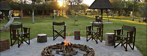 An outdoor seating area with chairs and a fire pit. - Fiume Lodge CC, P O Box 20757, Windhoek (Grootfontein)