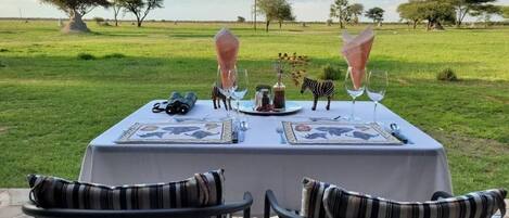 Una mesa al aire libre con vistas a un campo cubierto de hierba y árboles.