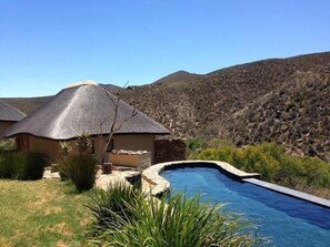 Una piscina al aire libre, sillones reclinables de piscina
