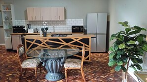 A compact kitchen with a central island, a refrigerator, and a microwave. - Q on First (Johannesburg)
