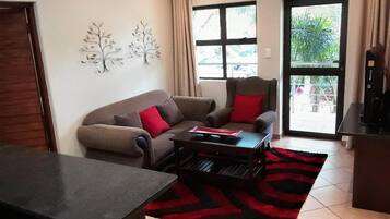 A living room with a sofa, a coffee table, and a rug.