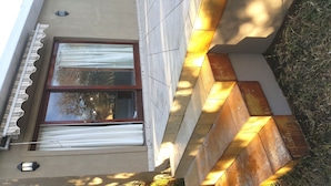 A modern building with a large window, a wooden staircase, and a small outdoor area with a light fixture. - 7 on Disa Self-catering Accommodation (Cape Town)