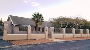 A residential house with a gated entrance, a sloped roof, and a palm tree in the yard. - 7 on Disa Self-catering Accommodation (Cape Town)