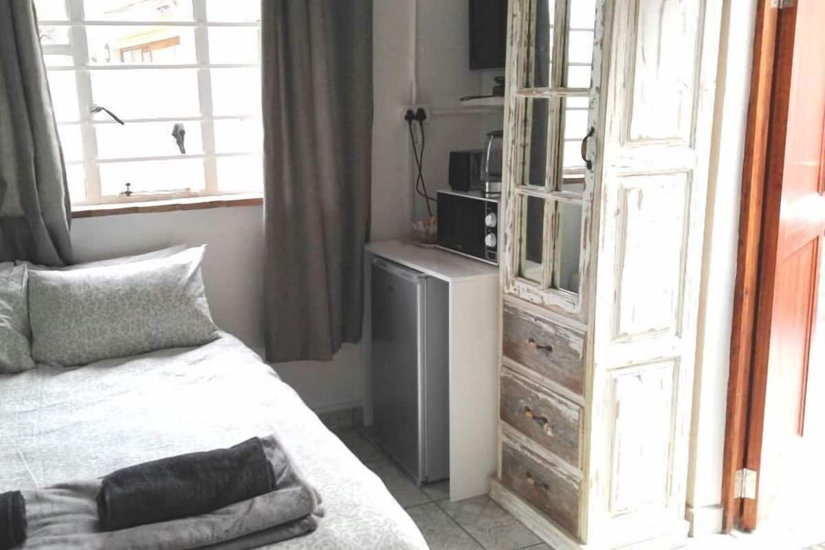 Une chambre à coucher avec un lit, un petit bureau et une armoire.