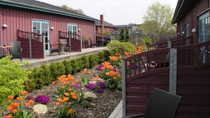 A red building with outdoor seating and a garden with colorful flowers. - Gerlev Kro & Hotel (Jægerspris)