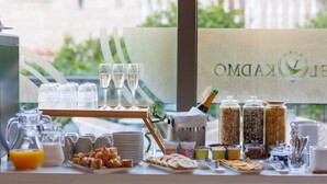 A breakfast buffet with various food items, drinks, and a champagne bottle. - Hotel Kadmo by Aycon (Budva)
