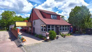 A two-story building with a red roof and a sign indicating a vacancy. - The Inn (Gravenhurst)