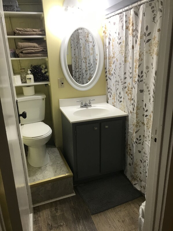 A compact bathroom with a toilet, sink, and storage cabinets.