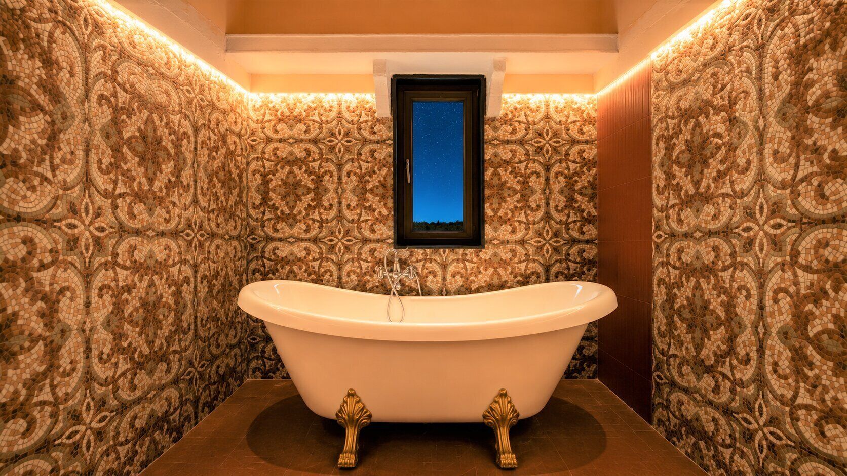 A freestanding bathtub in a bathroom with ornate mosaic walls and a framed picture above it.