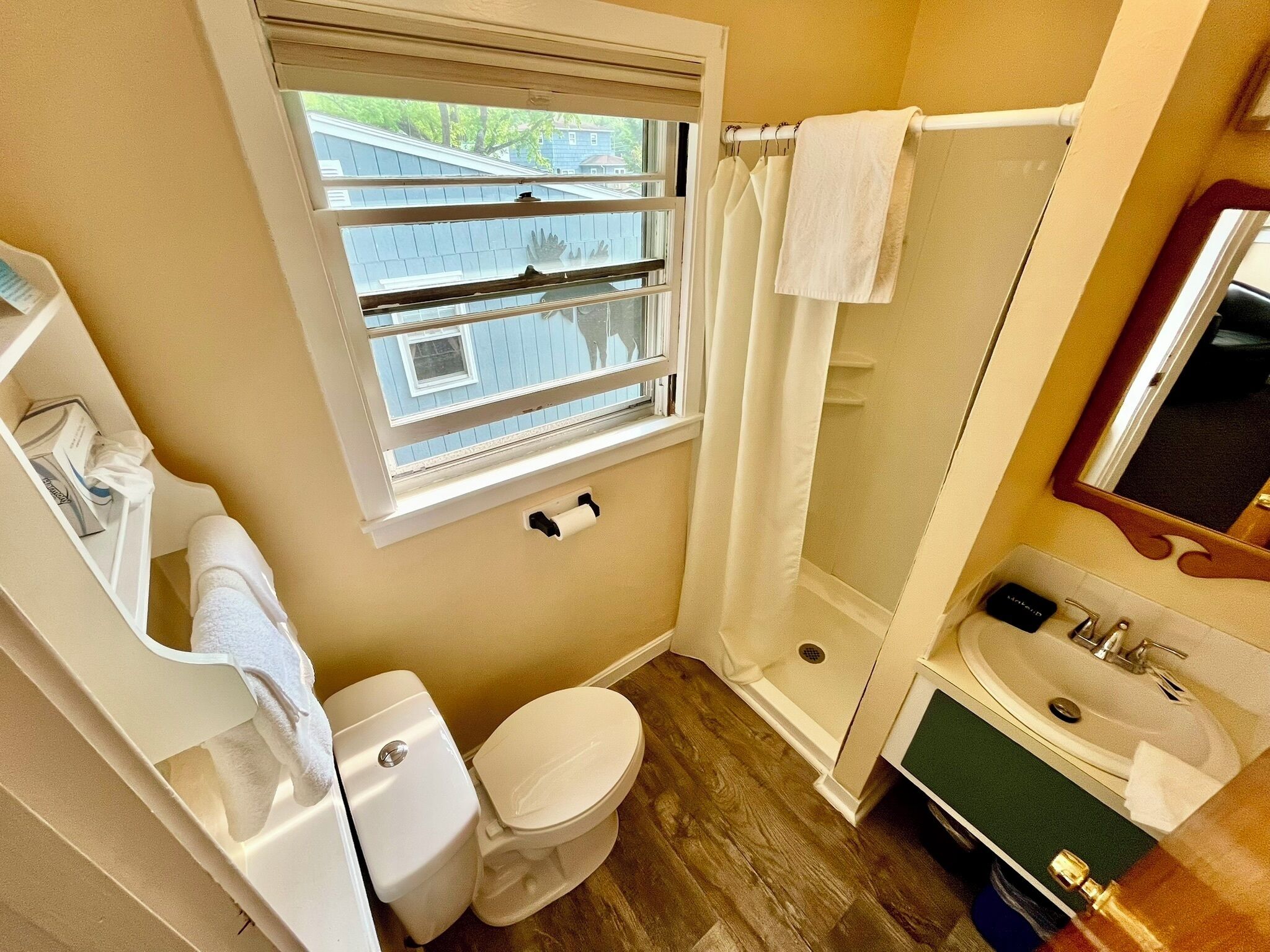 A bathroom with a toilet, sink, and shower.