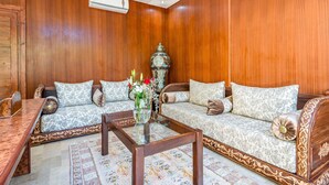 A traditional room with two sofas, a wooden coffee table, and a decorative vase.