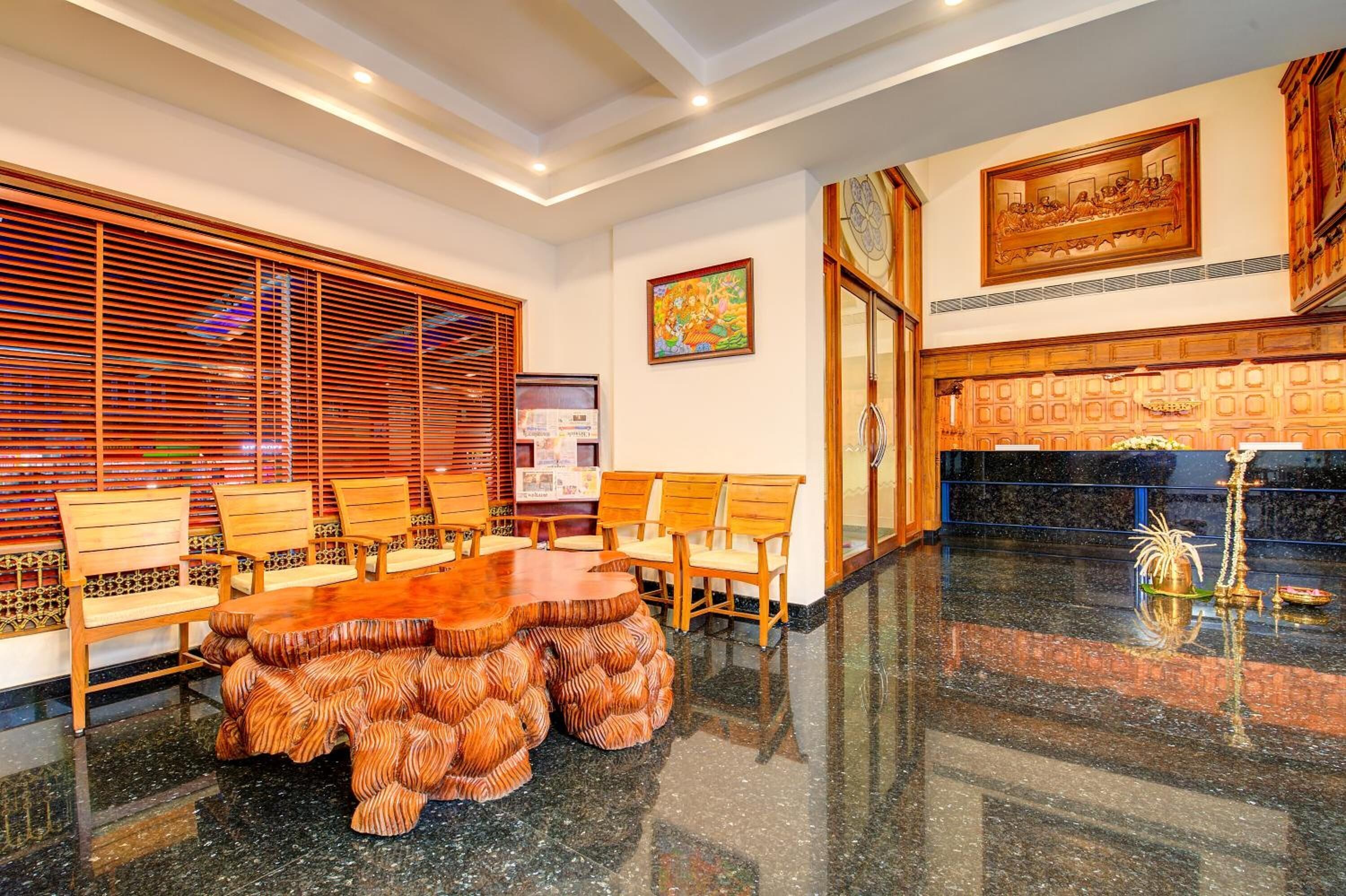 A spacious conference room with a large wooden table and chairs, a decorative wall panel, and a framed artwork above the fireplace.
