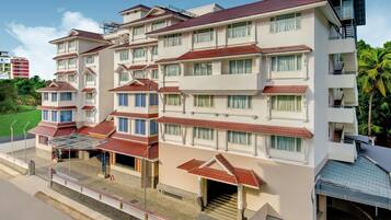 A multi-story hotel with a flat roof, balconies, and a covered entrance area.