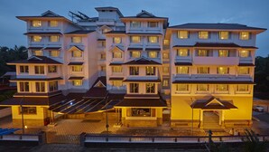 A multi-story hotel with a central entrance, multiple balconies, and a covered outdoor area. - Sterling Guruvayur (Chavakkad)