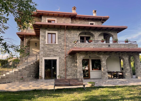 Traditional architecture meets serene surroundings in this charming two-story building with a balcony and staircase.