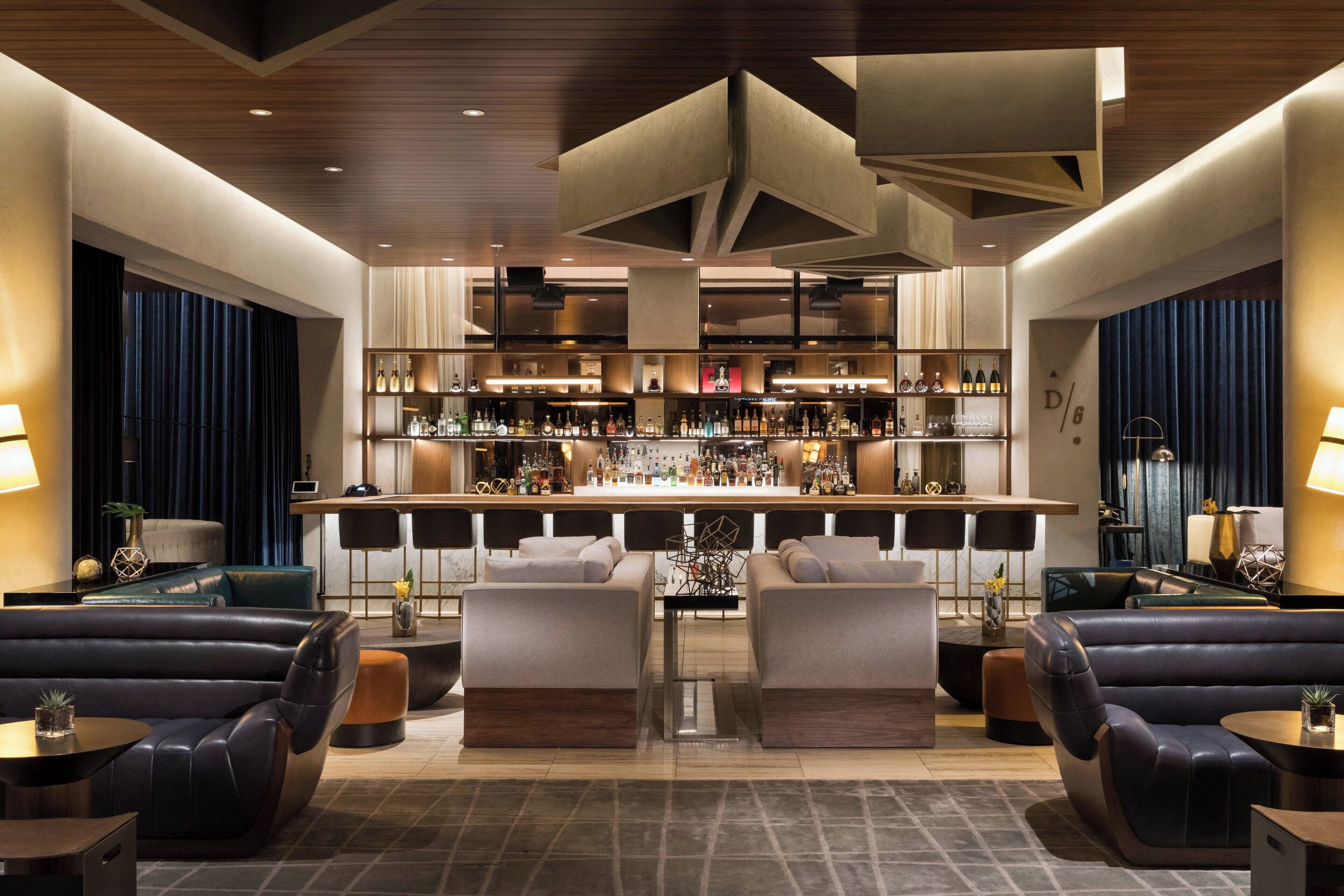 A modern bar area with leather seating and a well-stocked bar.