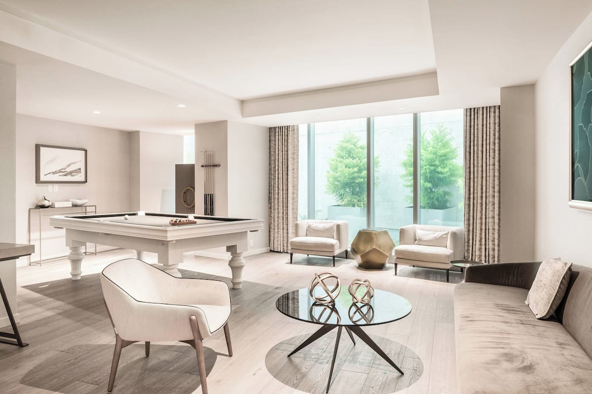 Una sala de estar moderna con mesa de billar, asientos cómodos y grandes ventanales con vistas al verdor.