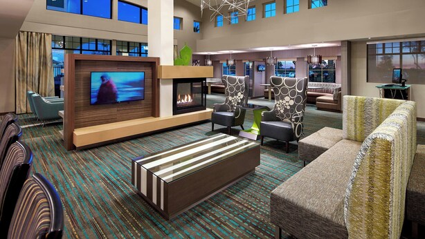 A spacious lobby with a flat-screen TV, a fireplace, and comfortable seating areas.
