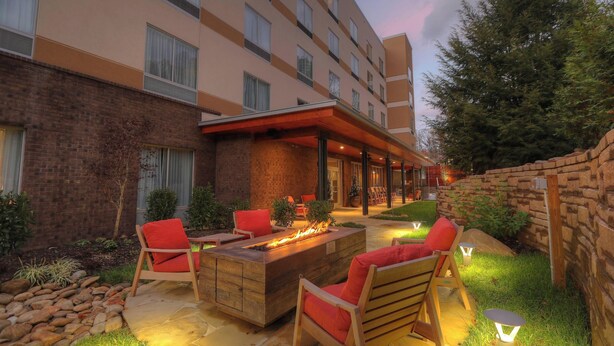 A hotel patio with outdoor seating, a fire feature, and a stone wall.
