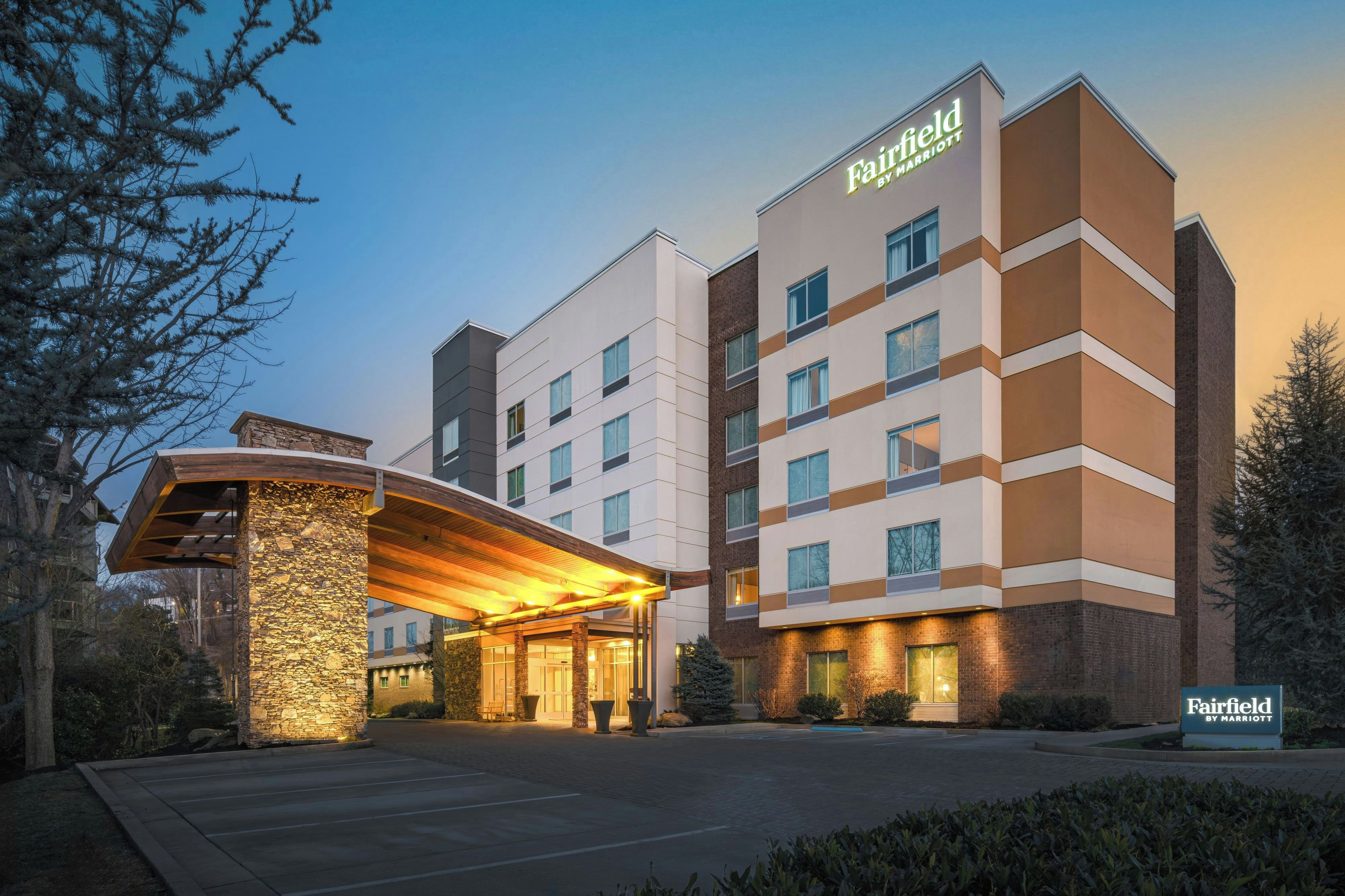 A Fairfield by Marriott hotel with a modern design, featuring a prominent entrance with a covered walkway and a stone facade.