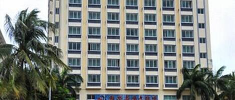 A multi-story hotel with a uniform facade, featuring a series of windows and balconies.