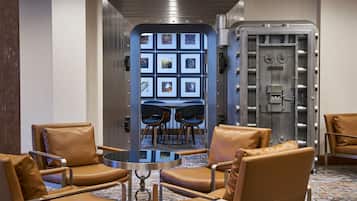 Relax in the hotel lobby's central seating area, surrounded by comfortable chairs and a round table.