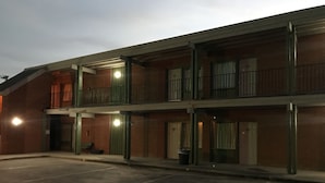 Ein zweistöckiges Motel mit Parkplatz davor.