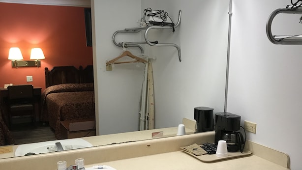 Ein Badezimmer mit Waschbecken, Spiegel und Handtuchhalter.