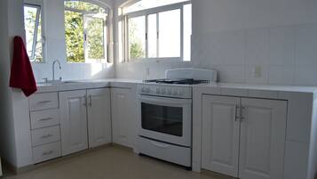 Frigorífico grande, horno, placa de cocina y cafetera o tetera