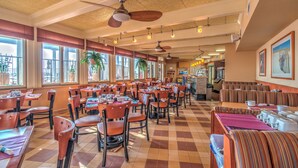 A spacious restaurant with high ceilings, large windows, and multiple dining areas. - Reges Oceanfront Resort (Wildwood Crest)