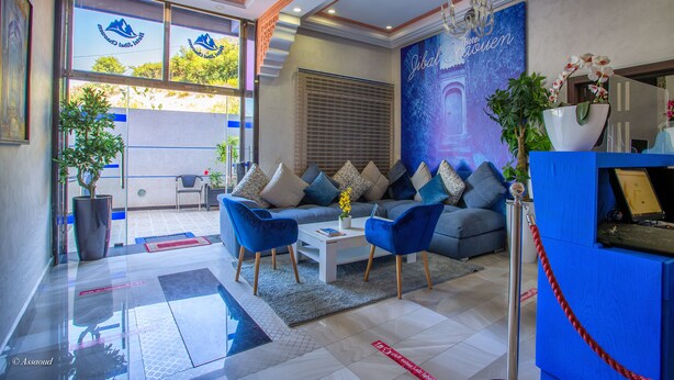 A modern hotel lobby with a sofa set, a coffee table, and a reception desk. - Hotel Jibal Chaouen (Chefchaouen)