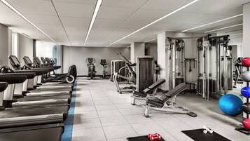 A gym with treadmills, weight machines, and exercise balls.