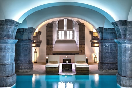 Una piscina techada, sillones reclinables de piscina