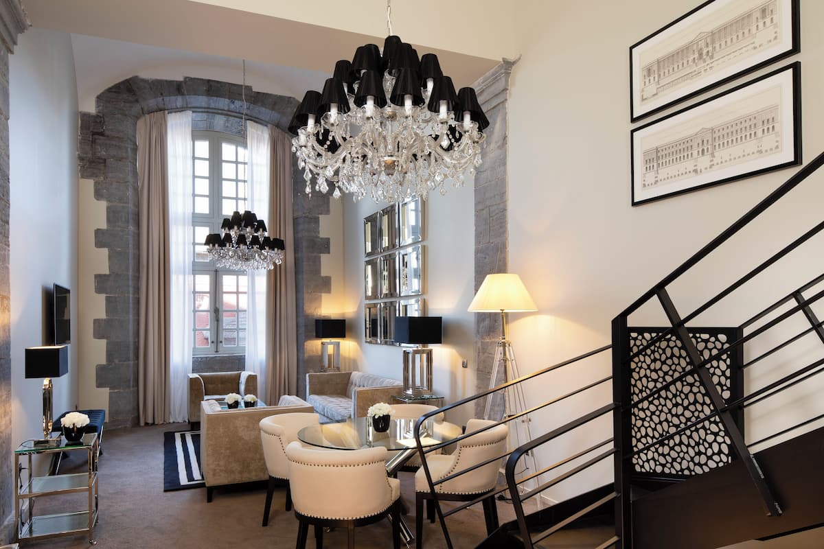 A modern living room with a chandelier, seating, and artwork on the walls.