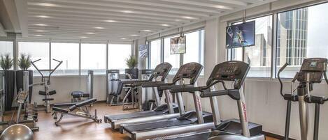 A gym with multiple treadmills, exercise balls, and weight machines.