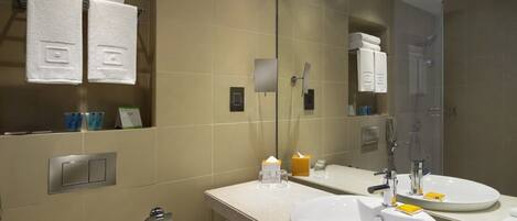 Un baño moderno con dos lavamanos, un espejo grande y barras para toallas.