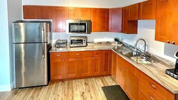Una cocina moderna con armarios de madera, electrodomésticos de acero inoxidable y encimera de mármol.
