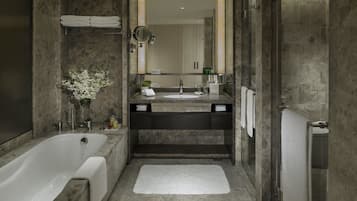 A modern bathroom with a large bathtub, a double sink vanity, and a mirror.