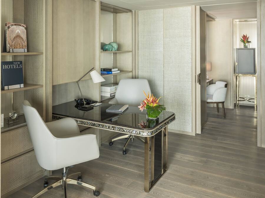 Une chambre d’hôtel moderne équipée d’un bureau, d’une chaise et d’une bibliothèque.