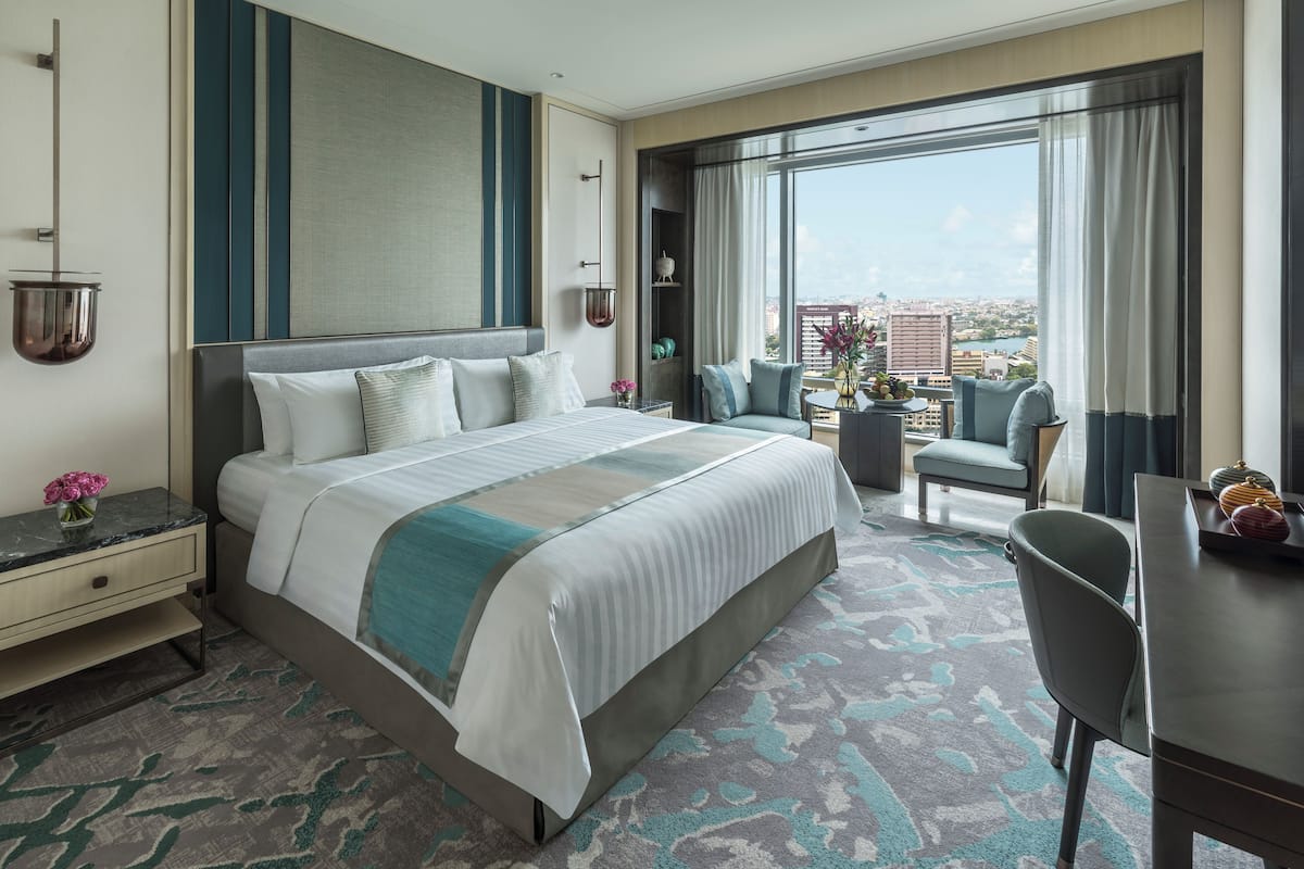 Une chambre d’hôtel moderne avec un grand lit, un bureau et une vue sur la ville.