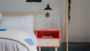 Une chambre à coucher avec un lit, une table de chevet avec une lampe, une horloge et une bibliothèque.