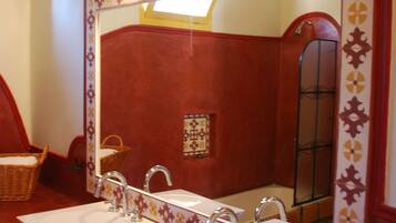 Un baño con dos lavamanos, un espejo grande y una pared roja.