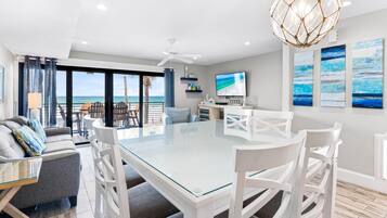 Relax in this stylish living room with a large dining table, comfortable sofa, and flat-screen TV.