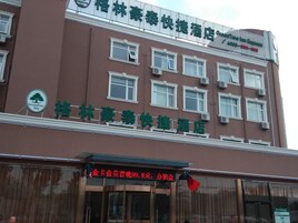 Un edificio de hotel con múltiples ventanas y un cartel que indica que es un GreenTree Inn.