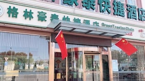 A hotel entrance with a sign for 'GreenTree Inn Chain' and Chinese characters.